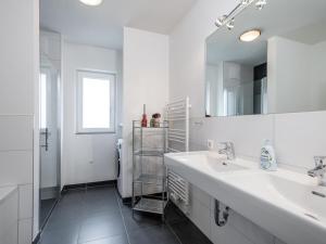 biała łazienka z 2 umywalkami i lustrem w obiekcie Panorama Top 2 w mieście Mauterndorf