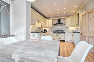 une cuisine avec une grande table et des chaises blanches dans l'établissement Host & Stay - Bellevue Road, à Ramsgate