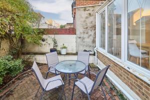 a patio with a table and chairs and a window at Host & Stay - Bellevue Road in Ramsgate