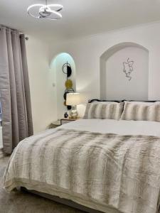 a white bedroom with a large bed and a window at Little Venice Garden Apartment in London