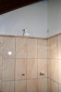 y baño con ducha y pared de azulejos. en Lago Manantial, en Independencia