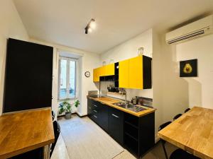 uma cozinha com armários amarelos e uma mesa de madeira em C&Y Apt - Roma Prati - Luxury two bedrooms Apartment em Roma