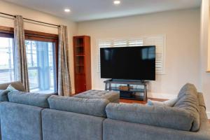 a living room with a couch and a flat screen tv at Oceanfront Family Retreat - Views, Wi-fi & A/C in Kaaawa
