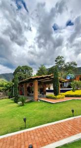 a house with a green yard with a building at NG Somos AT HOME Glamping a 20 min de Neiva in Neiva +21 photos