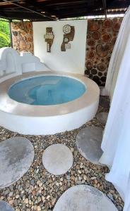 eine Whirlpool-Badewanne in einem Zimmer mit Felsen in der Unterkunft NG Glamping a 20 min de Neiva in Neiva