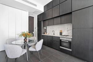 cocina con mesa, sillas y barra en East Central Apartment, en Sídney