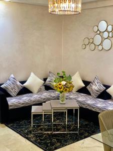salon z kanapą i wazonem kwiatów w obiekcie Appartement de lux w mieście Casablanca