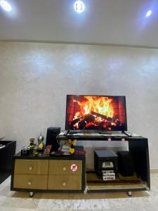 a tv on a stand with a fire on it at Appartement de lux in Casablanca