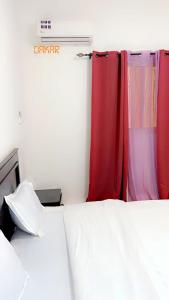 a bedroom with a bed and red curtains at Salam in Dakar