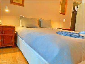 um quarto com uma cama grande e uma cómoda em madeira em SIX by UP Lisbon I Your home away from home em Lisboa