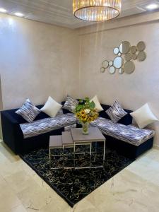 sala de estar con sofá con almohadas y mesa en Appartement de lux en Casablanca