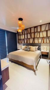 a bedroom with a large bed and two lights at CONDO VISTA AL MAR ZONA TEZAL in Cabo San Lucas