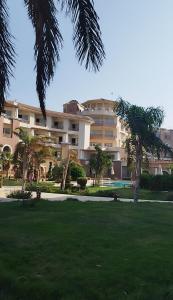 ein großes Gebäude mit Palmen in einem Park in der Unterkunft royal beach resort hurghada in Hurghada