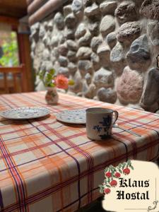 a table with two plates and a coffee cup on it at Hostal Klaus in Pucón