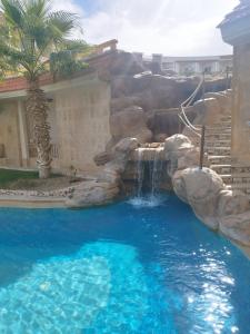 eine Wasserrutsche in einem Pool mit Wasserfall in der Unterkunft royal beach resort hurghada in Hurghada