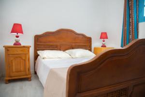 a bedroom with a large wooden bed with two lamps at L'Oasis à Tozeur in Tozeur