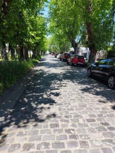 a cobblestone street with cars parked on the sides at Hostal NFrocket in Los Ángeles