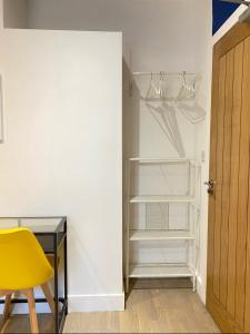 un armario vacío con escritorio y silla amarilla en En-suite near Stratford in a guesthouse en Londres