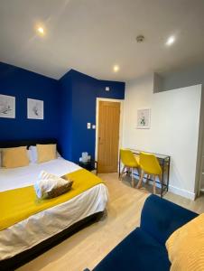 una camera con due letti e una parete blu di En-suite near Stratford in a guesthouse a Londra