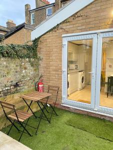 a patio with a table and chairs and a washing machine at En-suite near Stratford in a guesthouse in London