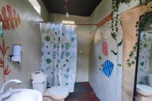een badkamer met een toilet en een douchegordijn bij Hostal La Buena Vida Mazunte in Mazunte