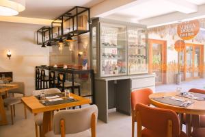 a restaurant with tables and chairs and a counter at Pousada Vila de Pedra in Jericoacoara