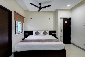 1 dormitorio con 1 cama grande y ventilador de techo en Townhouse Majestic Inn en Chennai