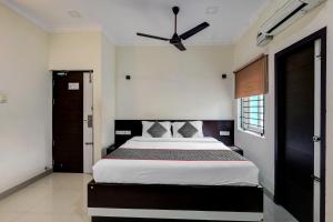 1 dormitorio con 1 cama y ventilador de techo en Townhouse Majestic Inn en Chennai