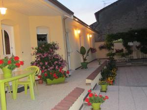 patio z kwiatami, stołem i krzesłami w obiekcie Charmante Chambres d'Hôtes au Cœur des Côtes de Toul, Proche Parc Lorraine & A31 - FR-1-584-189 w mieście Choloy
