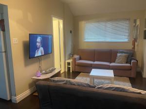 sala de estar con sofá y TV de pantalla plana en Downtown N. Vancouver Lane home, en North Vancouver