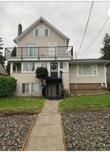 una casa grande con una escalera que conduce a la puerta principal en Downtown N. Vancouver Lane home, en North Vancouver