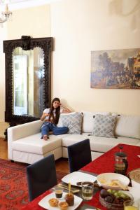 a woman sitting on a couch in a living room at Chiado apartments in Lisbon