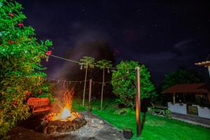 a fire pit with a bench in a yard at night at Amancay House in San Cristobal