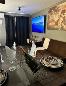 a living room with a bottle of wine on a table at Terraço Harmony Flats GRU in Guarulhos