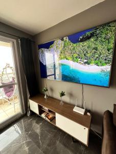 a living room with a large tv on the wall at Terraço Harmony Flats GRU in Guarulhos