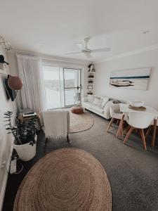 a living room with a couch and a table at Diggers Beach Villa Coffs Harbour in Coffs Harbour