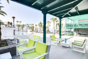a group of chairs on a patio with palm trees at Barceló Teguise Beach - Adults Only in Costa Teguise