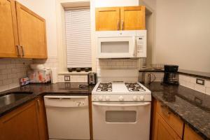 W kuchni znajduje się biała kuchenka i kuchenka mikrofalowa. w obiekcie Modern 4BR in Hyde Park, Walk to University w Chicago