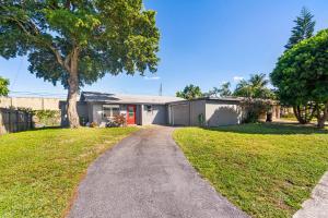 a house with a tree and a driveway at Luxe 4br Escape Pet-friendly Outdoor Lounge in West Palm Beach