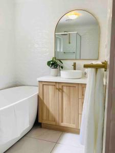 カイアマにあるSeabreeze Luxury Apartment Kiamaの洗面台、浴槽、鏡のあるバスルーム