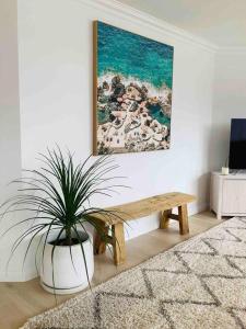 カイアマにあるSeabreeze Luxury Apartment Kiamaのリビングルーム(ベンチ、鉢植え付)