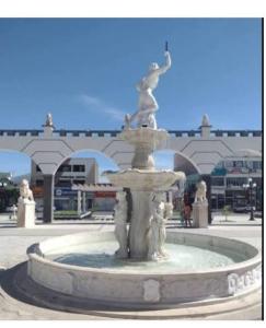 una fontana in mezzo a una piazza con un edificio di Hotel e Lanchonete Bom Gosto a Bom Jesus da Lapa