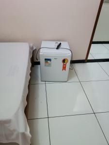 a white cooler sitting on the floor next to a wall at Hotel e Lanchonete Bom Gosto in Bom Jesus da Lapa
