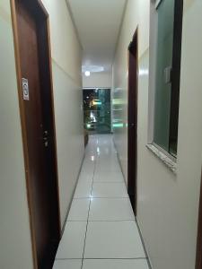 a long hallway with a tile floor in a building at Hotel e Lanchonete Bom Gosto in Bom Jesus da Lapa