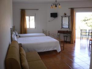 a bedroom with a bed and a couch and a tv at Kasimis in Kyparissia