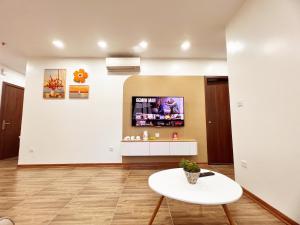 um quarto com uma mesa e uma televisão na parede em Happy Homestay 2 em Lạng Sơn
