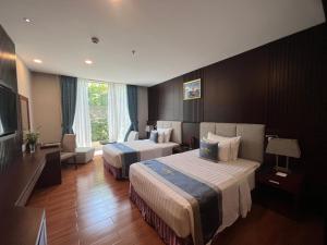 Habitación de hotel con 2 camas y TV en The Mira Hotel en Thu Dau Mot