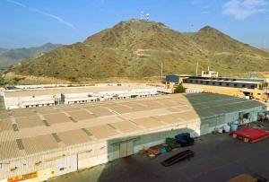 a large building with a mountain in the background at SHH Hotel in Fujairah