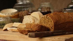 a loaf of bread on a cutting board with a knife at Jardin de Epicuro in Colonia Chapadmalal