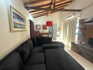 a living room with a black couch and a table at Casa La Galería in Asunción